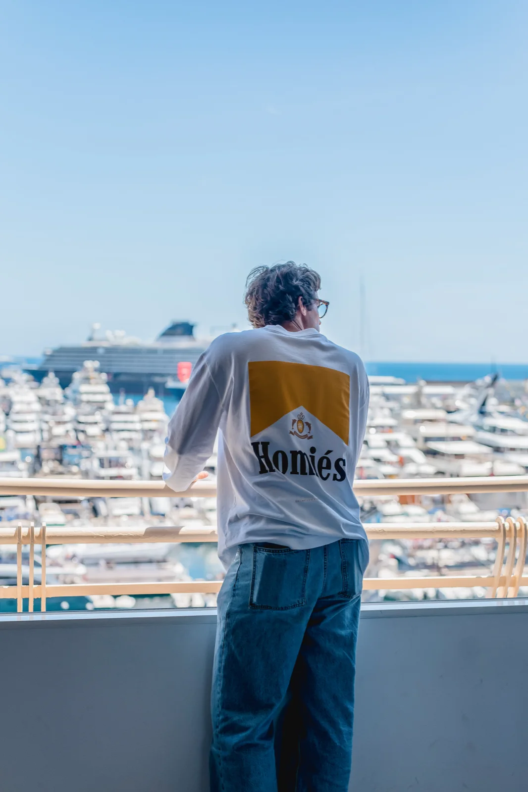 Invitado contemplando los yates del puerto de Mónaco desde una terraza